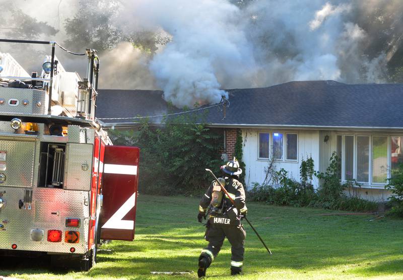Oregon firefighter Greg Hunter heads toward a burning home at 540 E. Elizabeth Road on Wednesday, Aug. 20, 2025. The home is located off South Daysville Road, southeast of Oregon.