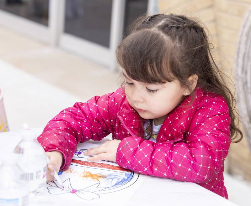Maya Witek, 3, of Oglesby colors an Easter Basket Saturday, March 30, 2024, on Court Street in Ottawa during the Hurray for Spring event hosted by Floret Events LLC and Garden's Gate Center Landscaping Inc.