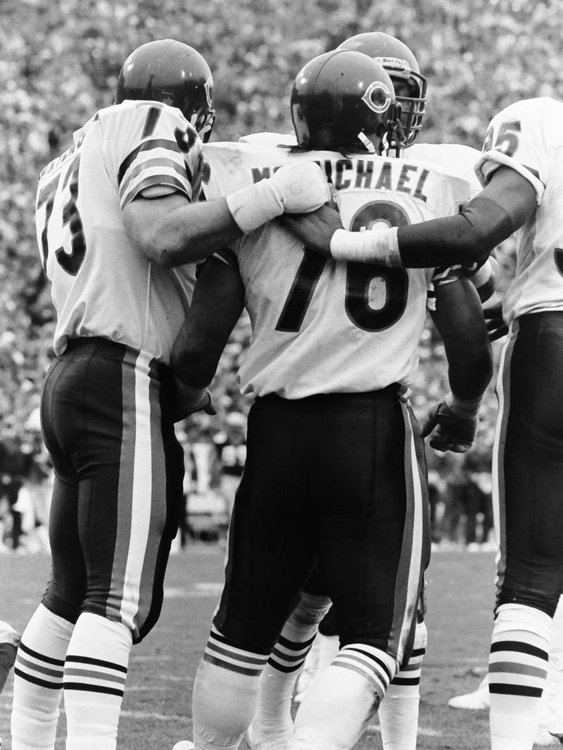 Chicago Bears defensive lineman Steve McMichael is hugged by teammate Mike Hartenstine during a game against the Green Bay Packers in 1985.