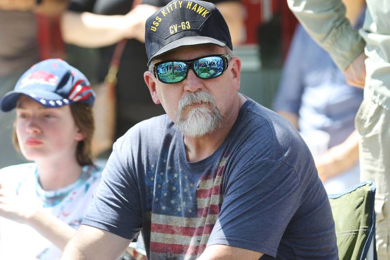 Liam Greenhill, 13, of Cary, sits next to his father, Jerry, a Navy veteran, as they watch the Wauconda Memorial Day Parade Monday, May 29, 2023, on Main Street. Jerry Greenhill grew up in Wauconda.