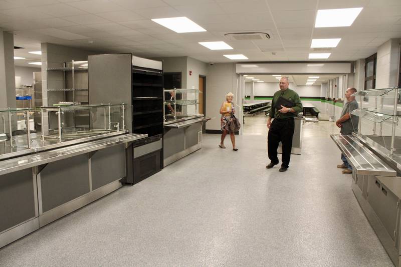 Rock Falls High School board member Jan McKanna, Superintendent Ron McCord and the district's facilities director Bryan Berogan review the completed service area of the renovated kitchen on Wednesday evening.