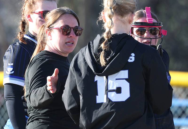 Hinckley-Big Rock head coach Abigail Christensen meets with her team on the mound during a break in the action Monday, March 23, 2026, during their game against Genoa-Kingston at Hinckley-Big Rock High School.