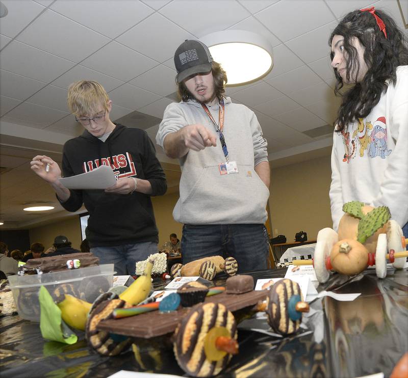 Judges Eli Keighin, Ethan Pico and Yesenia Valle look over and grade the edible cars Wednesday, Feb. 22, 2023, at the 18th annual Edible Car Contest at Illinois Valley Community College.