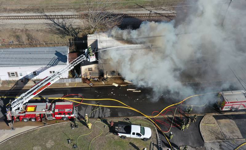 Peru firefighters use their aerial fire truck to spray water on top of the former Platform 31 tavern on Monday, March 24, 2025 on Water Street in Peru. The fire was upgraded to a three-alarm summing ire departments from La Salle, Utica, Mendota, Tonica, Ottawa, Ladd, Spring Valley, Lostant, Cedar Point, Troy Grove and Peru responded to the fire.