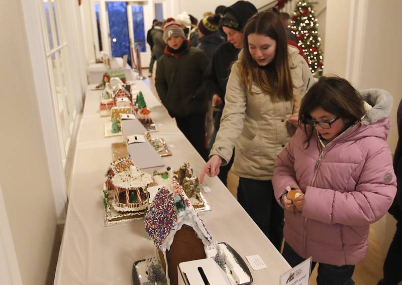 People look at the gingerbread houses in the Old Courthouse Center during the Lighting of the Square on Friday, Nov. 24, 2023, in Woodstock. The annual holiday season event featured brass music, caroling, free doughnuts and cider, food trucks, festive selfie stations and shopping.