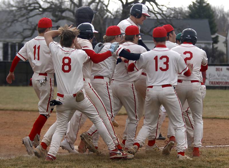 Huntley players mug Huntley's Joey Lengle after his walk in the ninth inning scored a run to win a nonconference baseball game against Fremd on Tuesday, March 24 2026, at Huntley High School.