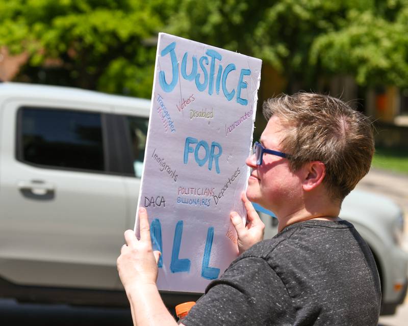 Danica Billingsly of Cortland holds a double-sided sign in support of transgender people during a Trans Resilience Rally held on Sunday, June 22, 2025, in downtown DeKalb. Organizers said the rally was to show public support for people they believe are unjustly and harmfully targeted under President Donald Trump's policies.