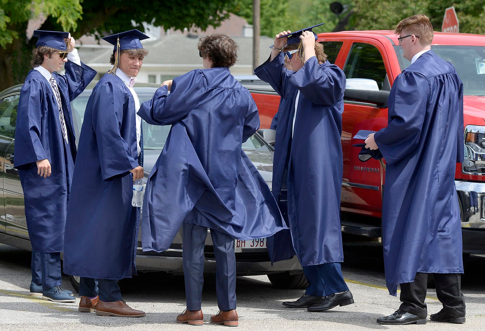 No dressing rooms necessary as Marquette Academy graduates get ready for the ceremony Sunday, May 28, 2023, in the parking lot at the school.
