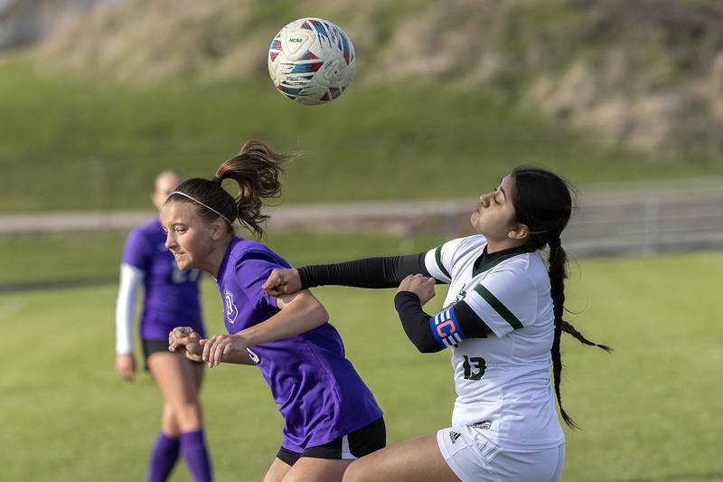 Dixon’s Jenna Harrison works against North Boone’s Ashley Lopez Tuesday, April 15, 2025.
