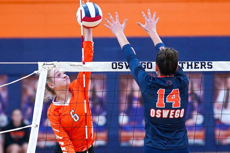 Minooka's Kendall Kozak (6) goes up for a kill attempt against Oswego’s Mia Jurkovic (14) during a volleyball match at Oswego High School on Thursday, Oct. 3, 2024.