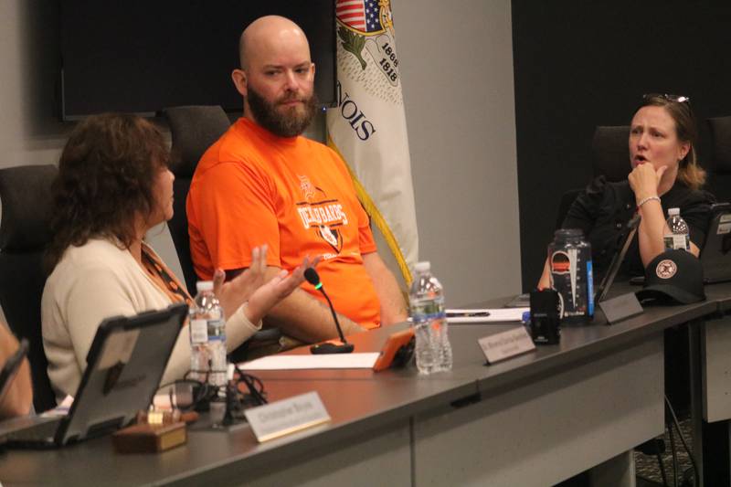 DeKalb School District 428 Board member Kristin Bailey (right) has an exchange Aug. 5, 2025, with Superintendent Minerva Garcia-Sanchez (left), as board member Steve Byers watches on.