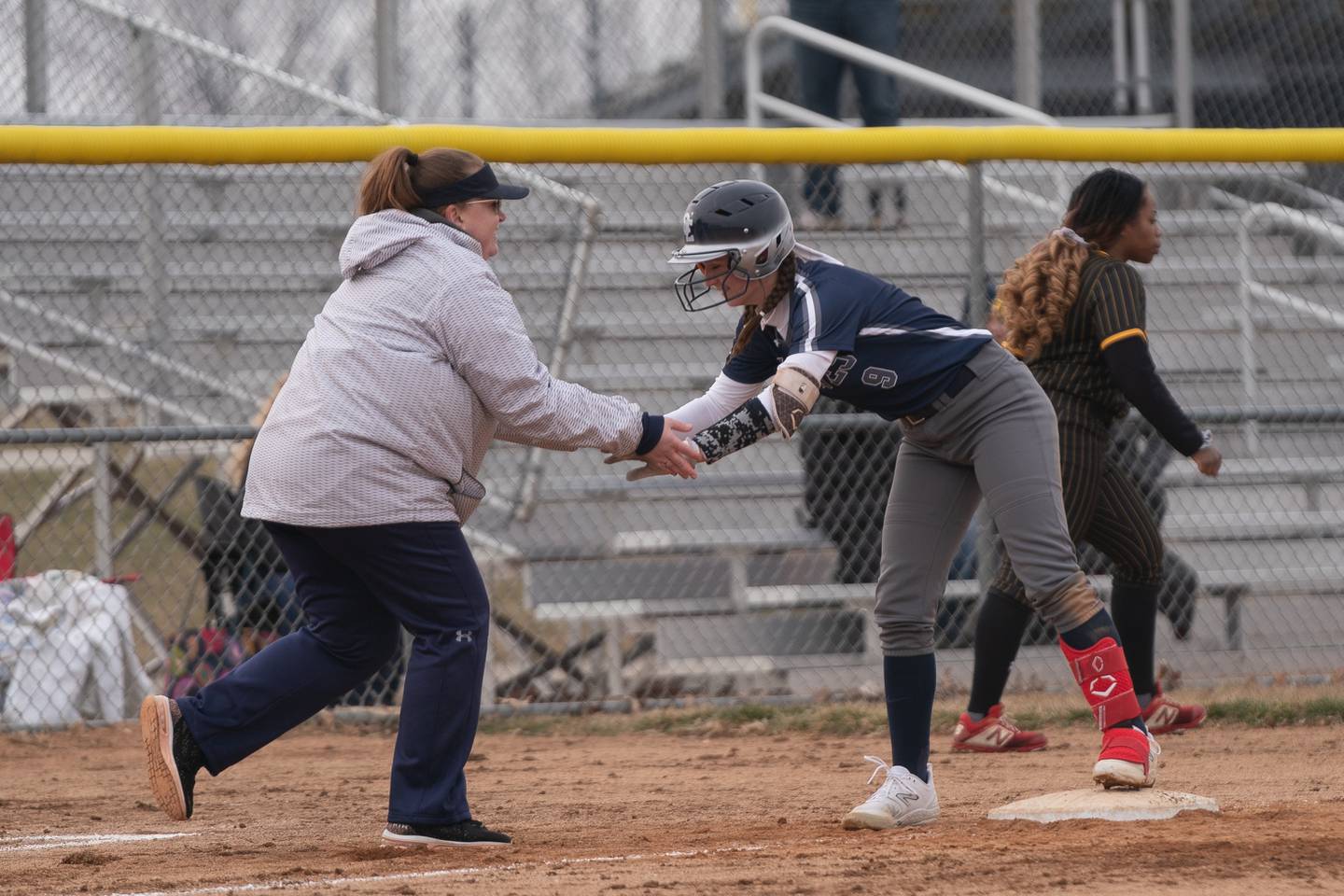 Oswego East's head coach Sarah Davies-Dymanus reacts after Kenzie Gatz (9) reaches third base on a triple against Metea Valley during a softball game at Metea Valley High School in Aurora on Friday, Mar 24, 2023.