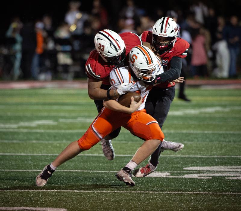 Bradley-Bourbonnais' Khalan Clemens, left, and Jayden Cooper, right, work to bring down Shepard's Billy Massey in a Class 6A playoff game on Friday, October 31, 2025.