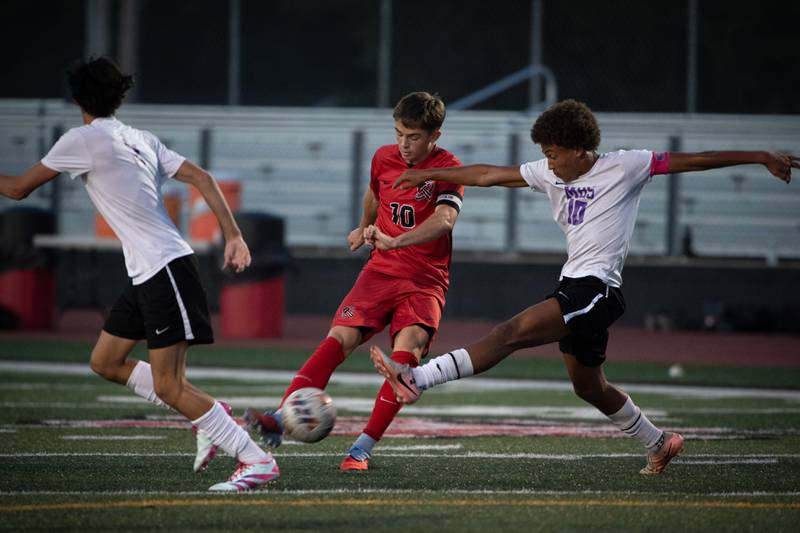 Bradley-Bourbonnais' Bennett Dykstra, center, tries to get a shot on goal as Manteno's Justin Foster, right, defends in a game on Tuesday, September 16, 2025.