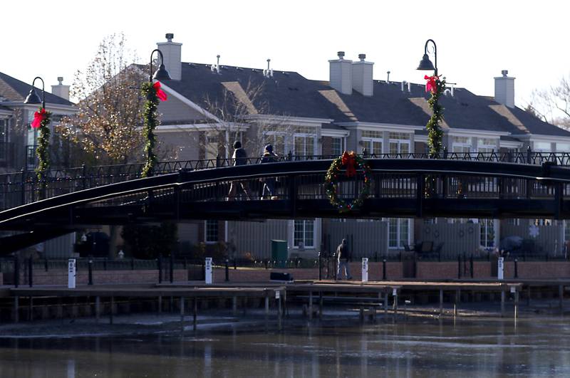 People cross Boone Creek on McHenry's Riverwalk on Thursday, Dec. 1, 2022.