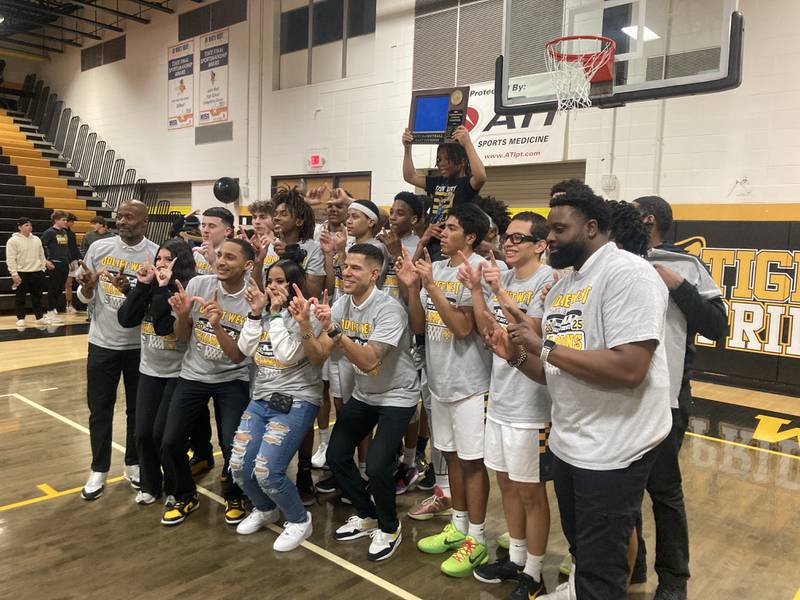 The Joliet West boys basketball team celebrates winning the Southwest Prairie Conference East Division.