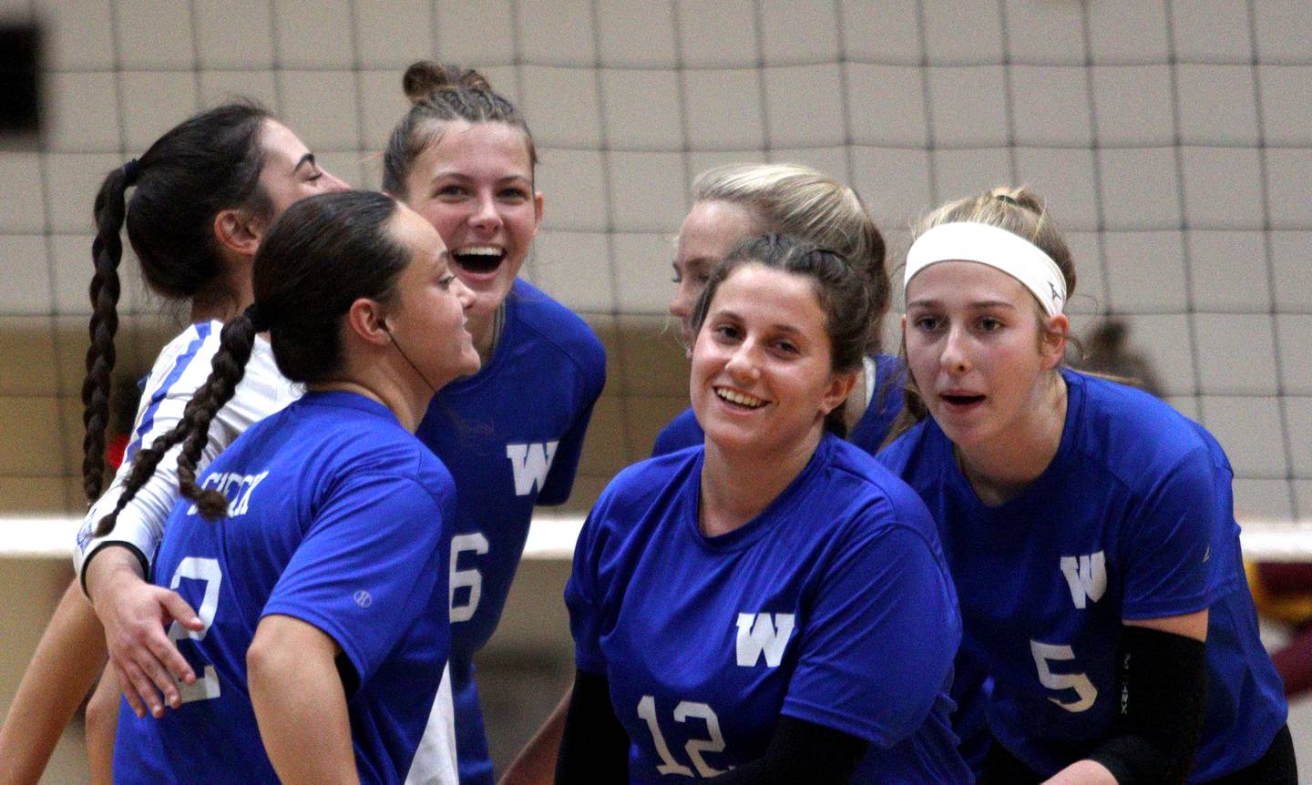 Woodstock’s Blue Streaks celebrate an early point against Richmond-Burton in varsity volleyball at Woodstock Monday night. The host Blue Streaks fell in two sets to the Rockets.