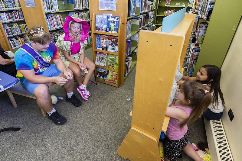 Petunia King Tyler Zepezauer and Pinky Petunia Emma Olson sit for a puppet show performed by Chella Hey (right), 5, and Lainey Hey, 7, Wednesday, July 3, 2024 at the Dixon library.
