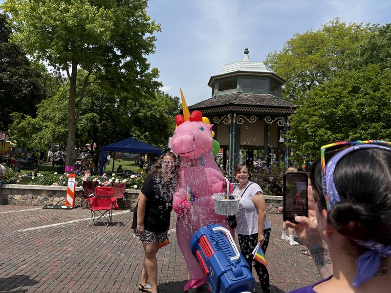 Christina Bidinger, left, and Sydney Bidinger take a photo with a unicorn during Woodstock PrideFest June 15, 2025.