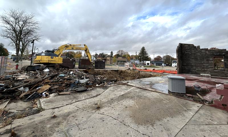 An excavator sits by debris from one of two buildings recently demolished in downtown Mt. Morris on Monday, Nov. 4, 2024. The buildings were destroyed by an April fire that was ruled undetermined in nature by the State Fire Marshal's Office.