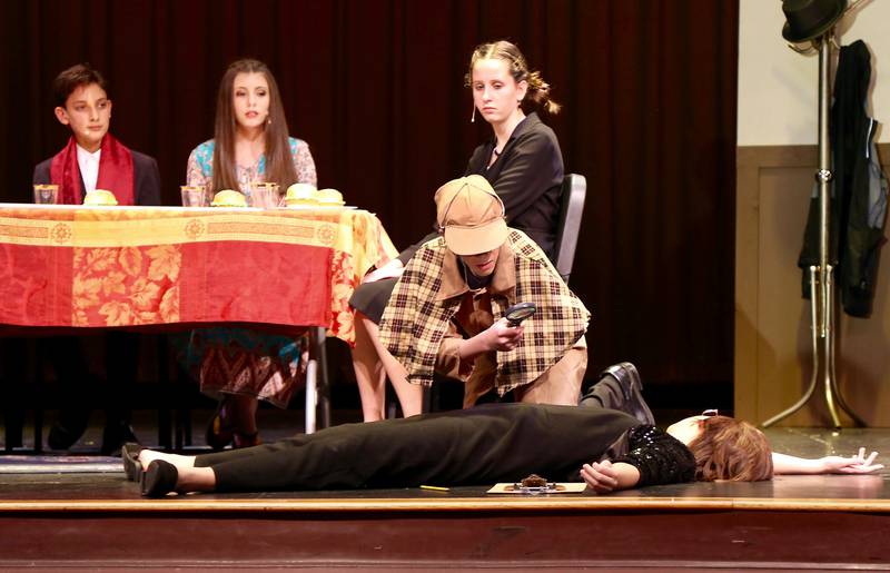 The Inspector (Jack Bicker) investigates the murder of The Host (Charlie Placzek) while The Ladykiller (Derin Cakmak), The Free Spirit (Rocklyn Sabathne) and The Lawyer (Sydney Konen) look on in Kaneland Harter Middle School’s production of “How to Host a Murder Mystery Dinner Party (In 15 Simple Steps)” on Saturday, Oct. 15, 2022 in Sugar Grove.