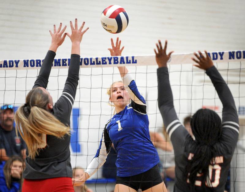 Newark's Addison Ness (1) knocks the ball over Aurora Christian defenders Maddie Johnson (left) and Dallas Ruff during a girls' volleyball match at Newark High School on Tuesday, Sep. 5, 2023.
