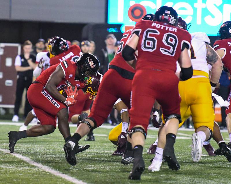 NIU Antario Brown, left carries the ball in the second quarter before being brought down by Central Michigan defenders on Wednesday Nov. 2nd at Huskie Stadium in DeKalb.