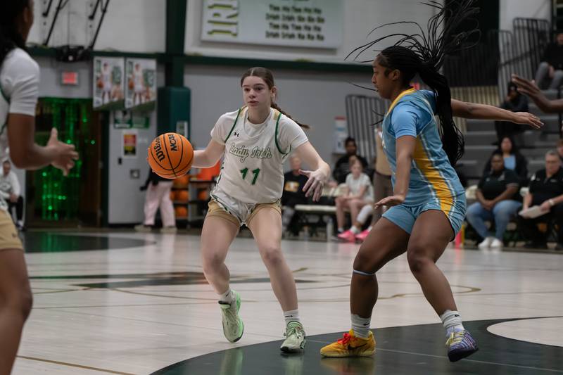 Bishop McNamara's Maggie Manes runs a play as Joliet Catholic's Gabrielle Gavin defends during Bishop McNamara's game against Joliet Catholic on Wednesday, Feb. 11, 2026.