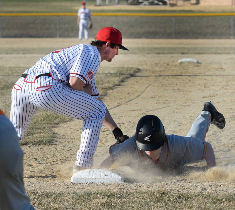 Forreston first baseman Alec Schoonhoven reaches to tag a Warren/Stockton player as he dives back to the base on Friday, March 28, 2025 in Forreston.
