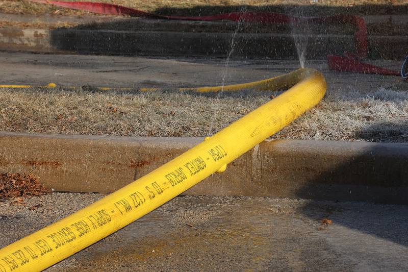 Water bursts from a charged fire hose as firefighters work to extinguish a fully engulfed house fire in the 800 block of Bucklin Street on Friday, Jan. 23, 2026 in La Salle.