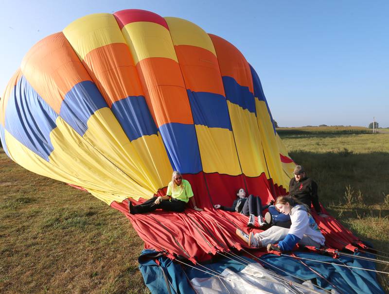 (From left) Elsie Cloyd, Emma Carlson, Candance Lesman and her father Isaac lay on a hot air balloon after landing in a farm field near Tiskilwa during the 52nd annual Homestead Festival on Saturday, Sept. 9, 2023 in Princeton.