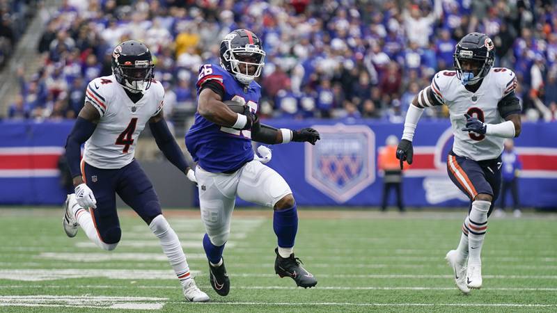 New York Giants running back Saquon Barkley runs the ball against Chicago Bears safeties Eddie Jackson, left, and Jaquan Brisker during the second quarter, Sunday, Oct. 2, 2022, in East Rutherford, N.J.