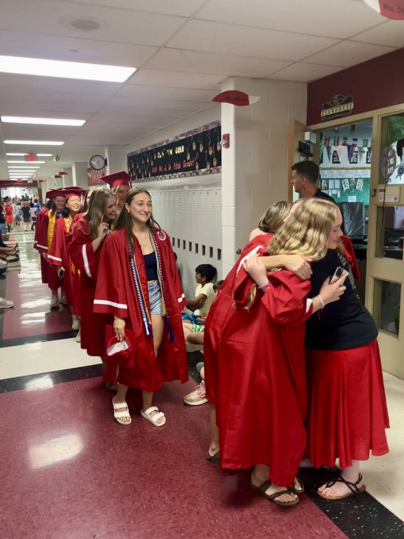 Yorkville High School seniors paraded through their old haunts, Grande Reserve Elementary School, stopping to give hugs to their former teachers.