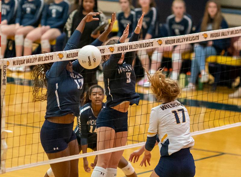 Oswego East's Vivian Campbell (17) and Kylie Kany (9) defend the net against a kill attempt by Neuqua Valley's Brianna Clasen (17) during the Neuqua Valley 4A regional final volleyball match at Neuqua Valley High School in Naperville on Thursday, Oct 27, 2022.