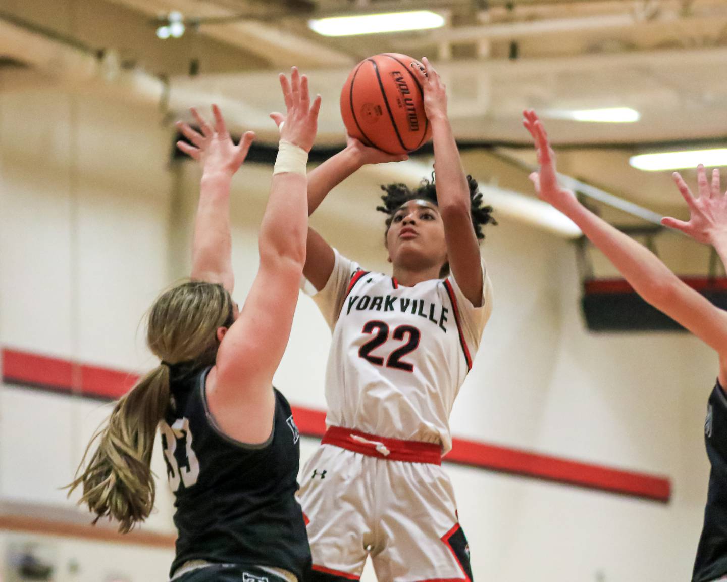 Yorkville's Alex Stewart (22) puts up a jump shot over Kaneland's Natalie Myers (33) during varsity basketball game between Kaneland at Yorkville. Dec 14, 2022.
