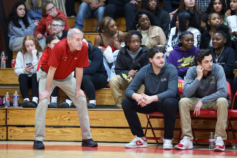 St. Anne head coach Rick Schoon, left, watches a play next to his son and assistant coach Brooks Schoon, seated left, during St. Anne's 64-43 victory over Momence in the River Valley Conference semifinals on Tuesday, Feb. 10, 2026. The win tallied Schoon's 500th career coaching victory.