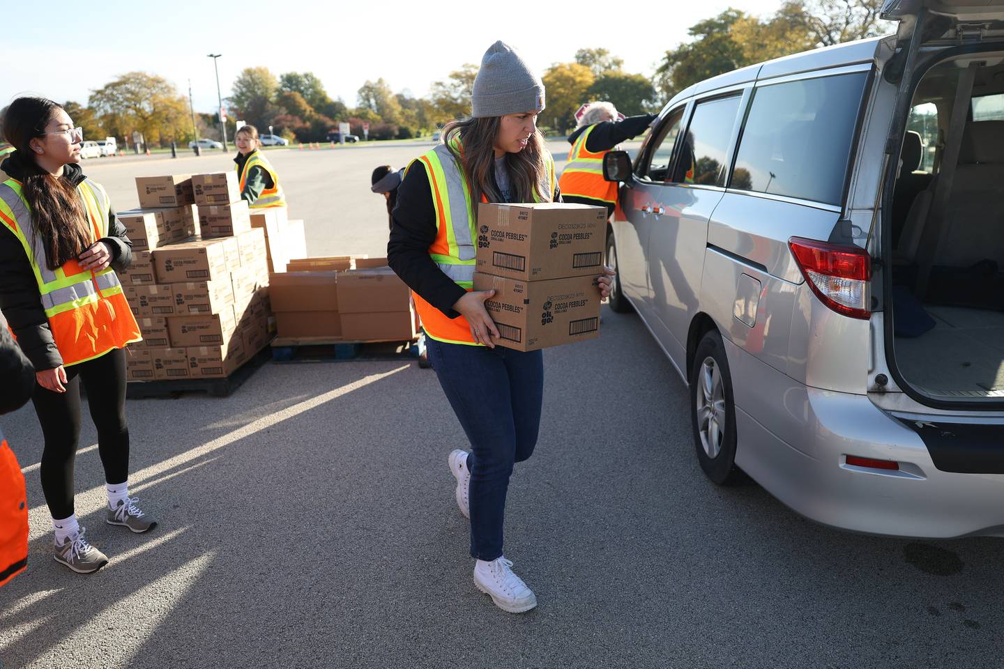 Volunteer Janelly Plascenca loads groceries into a van at Joliet Junior College on Saturday, Oct. 21. With inflation and rising food costs, Northern Illinois Food Bank held a Free PopUp Grocery Distribution giving away groceries to 700 families.