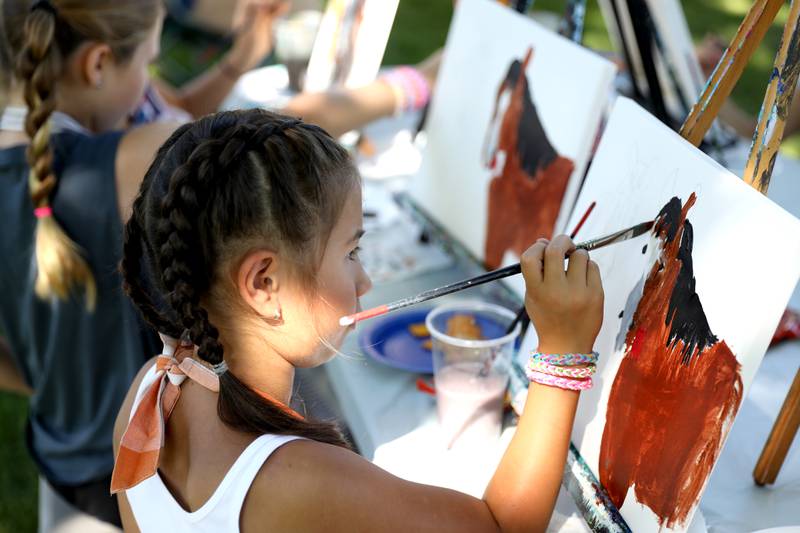 Gretchen Kuang, 7, of Sycamore works on a painting of horses during a painting class with Chelsea McGhee Studios at the Little Cottage on the Farm in Kaneville on Thursday, July 27, 2023.