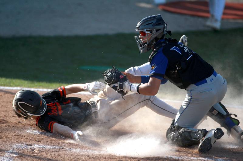 Wheaton Warrenville South's Aidan Quartz slides into home plate under Geneva's Alex Abraham during a game on Monday April 14, 2025 in Wheaton.