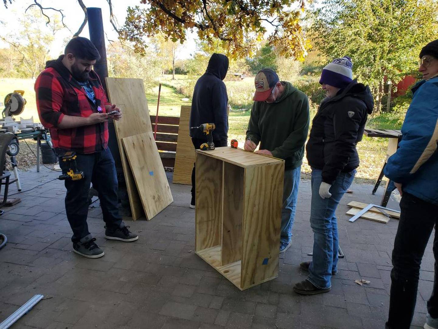 Volunteers helping Shirley Stockwell build Little Free Library helping her earn Eagle Scout ranking.
