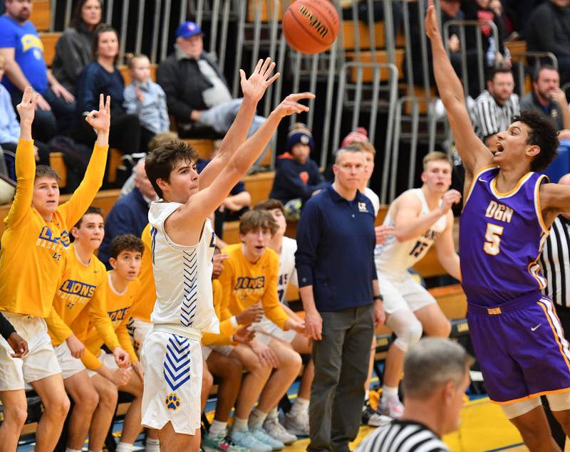 Lyons Township's Matthew DeSimone (left) puts up a shot from three point range as Downers Grove North's Jacob Bozeman defends during a game on Jan. 6, 2023 at Lyons Township High School in LaGrange.