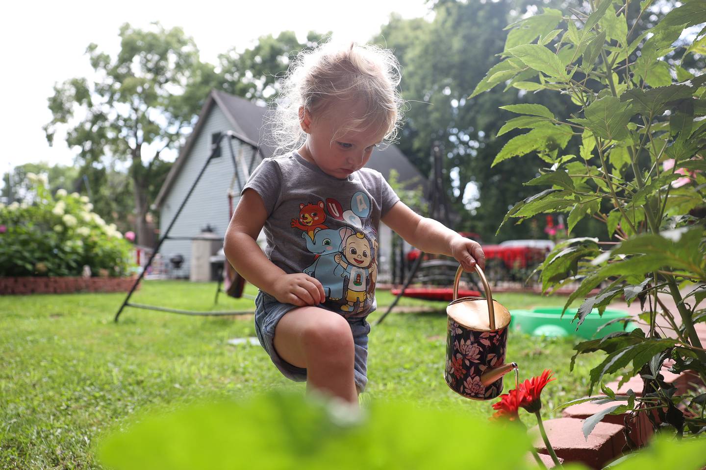 Addylinn Horton, 3-years old, helps water her grandmother Daniell Gorman’s garden on Friday, Aug. 25, 2023.