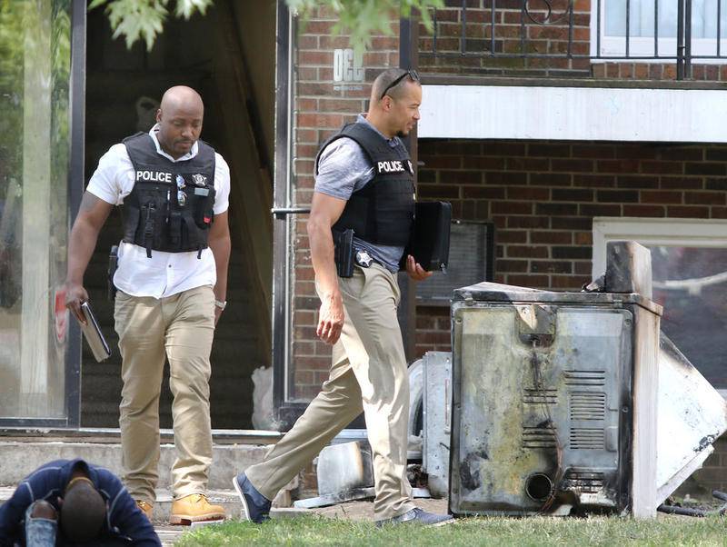 Northen Illinois University Police officers exit a building at 930 Greenbrier Road in DeKalb Thursday after a suspicious morning fire at the location. This building is owned by Hunter Properties who also own Ridgebrook Apartments where a fire that occurred Tuesday night is under investigation.