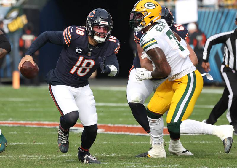 Chicago Bears quarterback Caleb Williams scrambles through a hole in the Green Bay Packer defense for a good gain Sunday, Nov. 17, 2024, during their game at Soldier Field in Chicago.