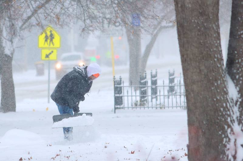 Luis Palencia of Marengo shovels during a snow storm in Marengo on Saturday, November 29, 2025.