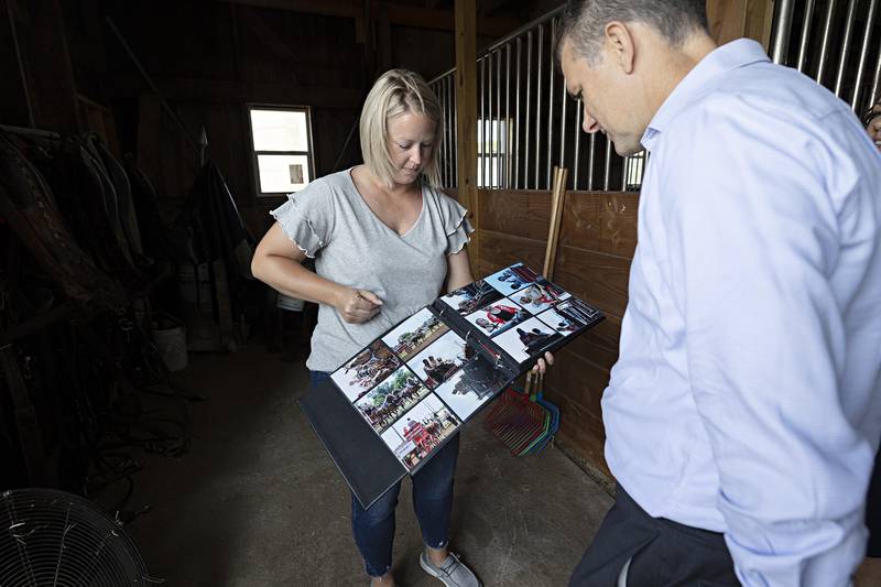 Amanda Mosher displays an album of pictures of the various shows the family has entered their team in during the Senator’s visit Tuesday, July 25, 2023.