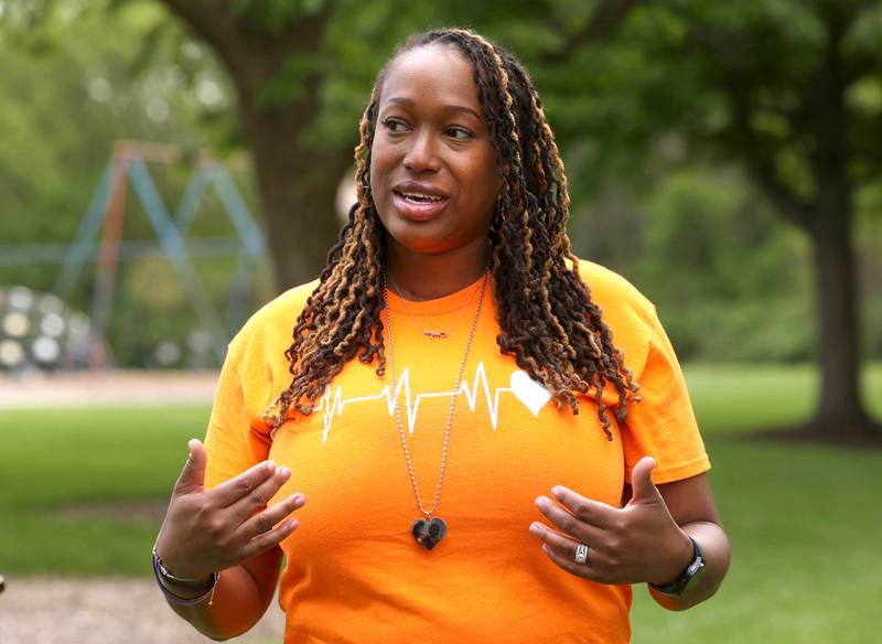Andrea Elion, mother of Ezra Hill Jr. talks Monday, May 12, 2025, about him as she stands next to a tree and rock garden at Tyler Elementary School, where he attended, that is dedicated to his memory. Hill was murdered in 2019 in Harvey, and the Fifth Annual Ezra Hill Jr. Memorial Rock Painting event will be held on June 7 at the school in DeKalb.