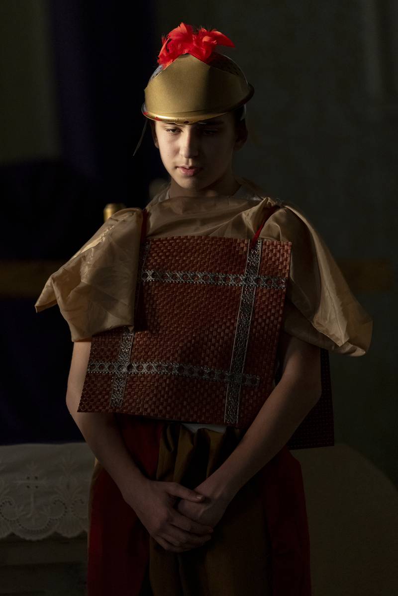 Weston Frick portraying a guard looks down at Jesus after he falls to the ground for the second time during the Stations of The Cross event on April 16, 2025 at St. Patrick's Church.