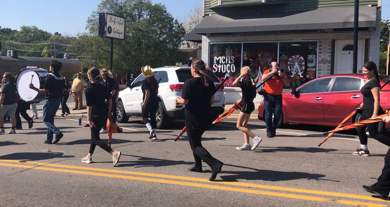 Members of the McHenry High School band walk by Black Orchid Boutique in the McHenry High School Homecoming parade Oct. 6, 2024.
