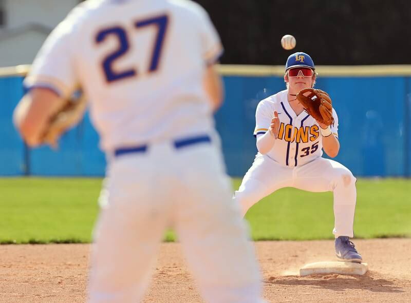 Lyons Township's Troy Stukenberg (35) catches a throw from Jack Falls (27) to start a double play during the boys varsity baseball game between Lyons Township and Downers Grove North high schools in Western Springs on Tuesday, April 11, 2023.